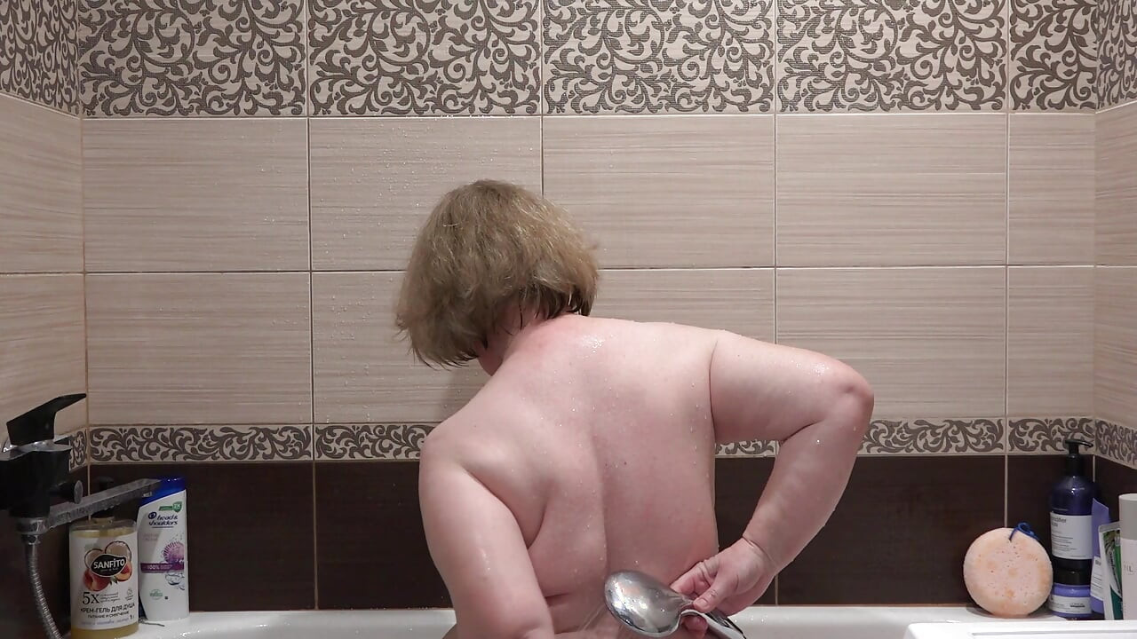 La madrastra madura se masturba cuando se ducha. La cámara de casa en el baño vigila al gordito.