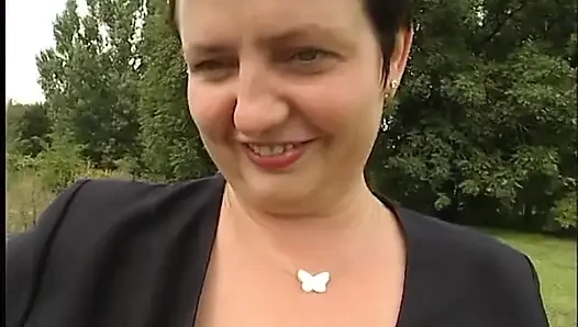 Lovely mature lady blows a guy's cock outdoors near the car