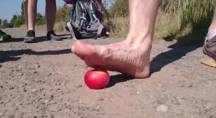 Young gay crushes apple in the dust while hiking
