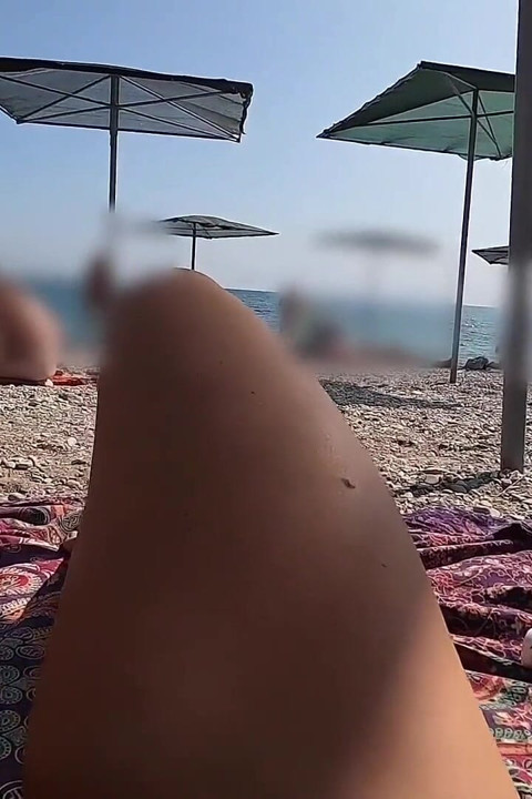 Olie op mijn naakte lichaam wrijven op een strand terwijl mijn man me filmt
