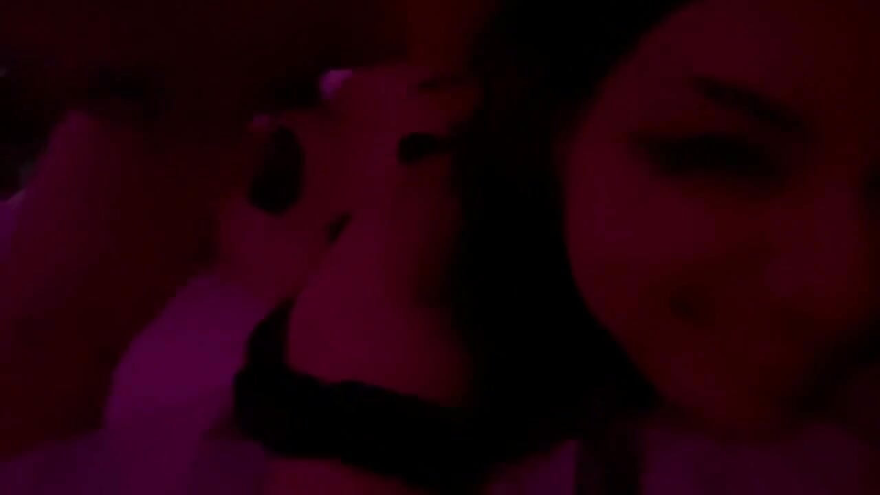Pareja real en momento íntimo bajo luces rojas