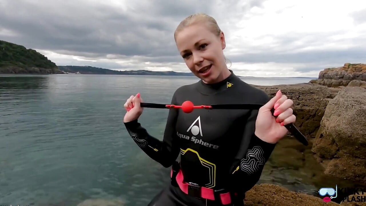 वेटसूट में बॉलगैग के साथ महासागर रस्सी बंधन