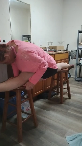 Splits on two stools in orange dress