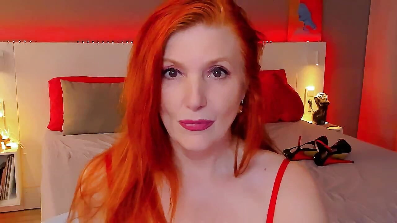 Red-haired lady shows her charms on the bed