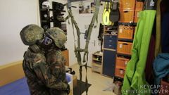 Zwei Soldaten im deutschen Flecktarn in Gasmasken wichsen