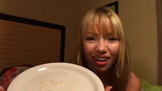 Красивая азиатская девушка плюет мокротой на тарелку и показывает нам
