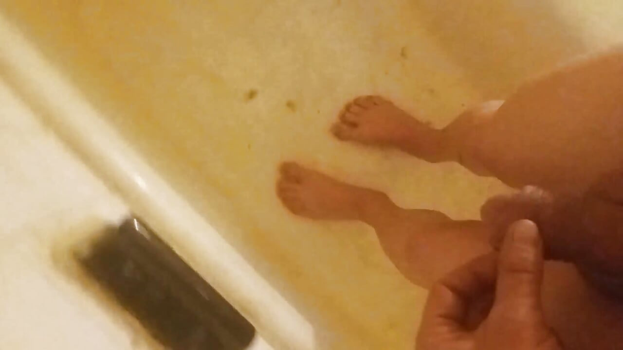 Je pisse à poil et pieds nus sur mes pieds, dans une baignoire