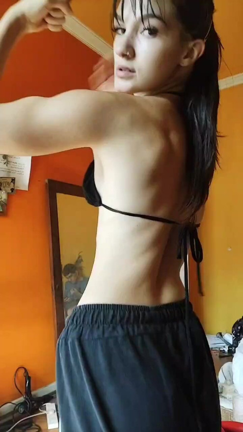 Petite fitness girl flexing her biceps