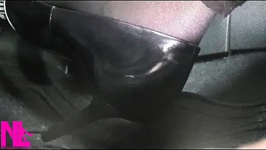 Menyadarkan dan mengemudi dengan stoking hitam dan sepatu hak tinggi abu-abu