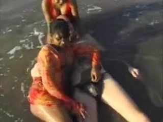 2 indyjskie dziewczyny z białym facetem na plaży bawią się lodzikiem ..