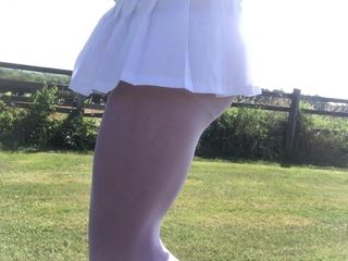 Wietrzna w białych rajstopach i plisowanej mini spódniczce