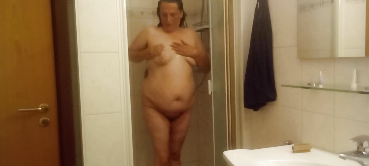 Zrela bucmasta žena pod tušem sa velikim stomakom se može dobro videti