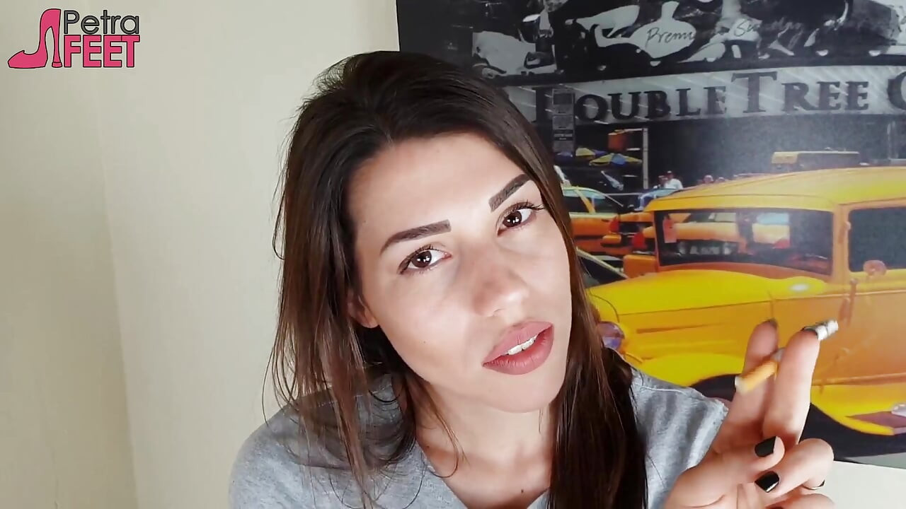 Wunderschöne brünette raucht eine zigarre in ihrem schlafzimmer