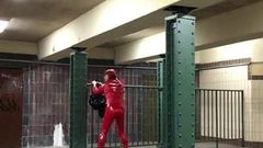 赤いポリ塩化ビニールのスーツを着た駅でのクルージング