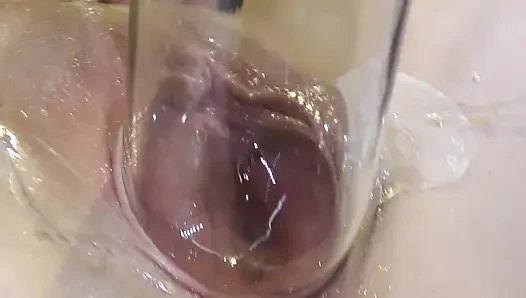 Çok yakından dildo ve camla geniş yayılmış vaginasını sevişmek