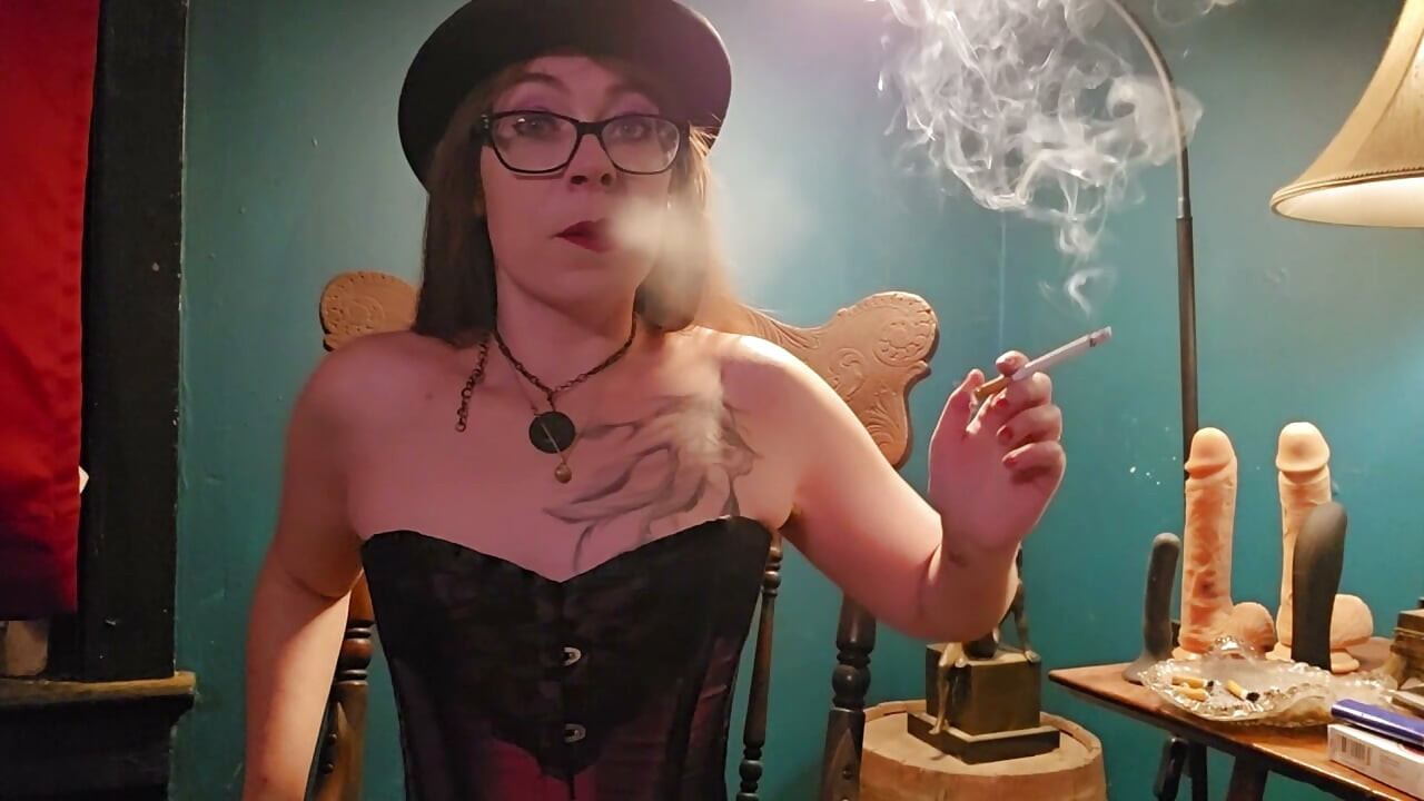 Rokend in een paarse corset, handschoenen en een hoed