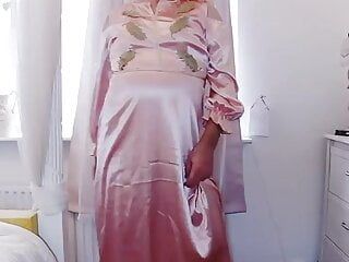 Sissy travestiet in lange roze satijnen jurk