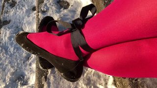 Crossdresser posando de meia-calça rosa na escada de neve