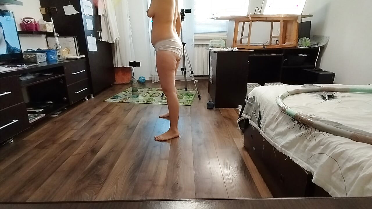 Amateur woman has fun trying on clothes and cutting them. Amateur woman vacuums naked in the house.
