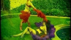 Deux strip-teaseuses blondes psychédéliques en lingerie font une sale danse seins nus dehors