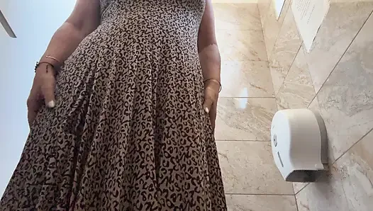 A horny mature MILF is very aroused and is rubbing her pussy in the public restroom at the office.