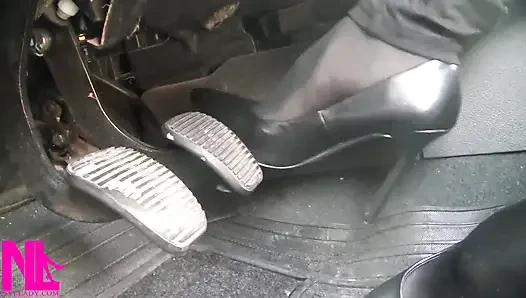 Siyah külotlu çorap ve gri patentli yüksek topuklu ayakkabılarla pedal pompalıyor