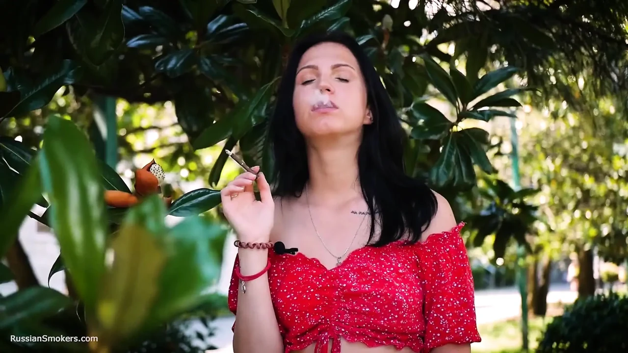 Sultry Brunette in Red Dress Smoking Rolled Cigarette