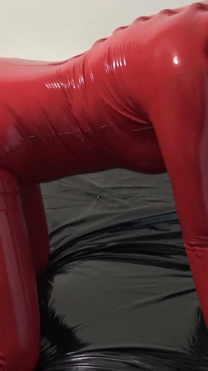 Photoshooting in Red Latex Catsuit with Latex Mask and Transparent Face.