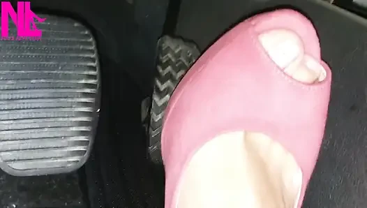 Canlı pembe yüksek topuklu sandaletlerle yalınayak sürüş ve canlandırma
