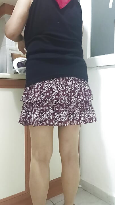 Mature woman in sheer stockings doing housework in the kitchen.
