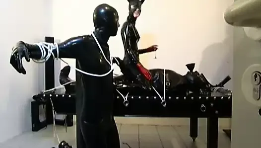 three latex cats tie up their submissive slave