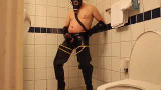 Rubbergloved masturbarse en la ducha del hotel usando botas