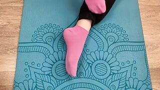 Chica fitness hace ejercicios en la estera en calcetines y le da una paja con los pies a su entrenador con semen en los pies