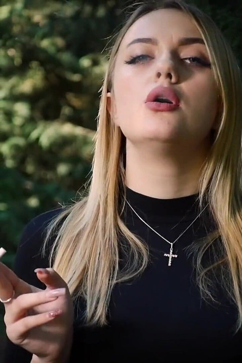 Heißes blondes schätzchen raucht eine schwarze zigarette in der natur