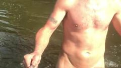 Nudista flaca sumergiéndose en el río
