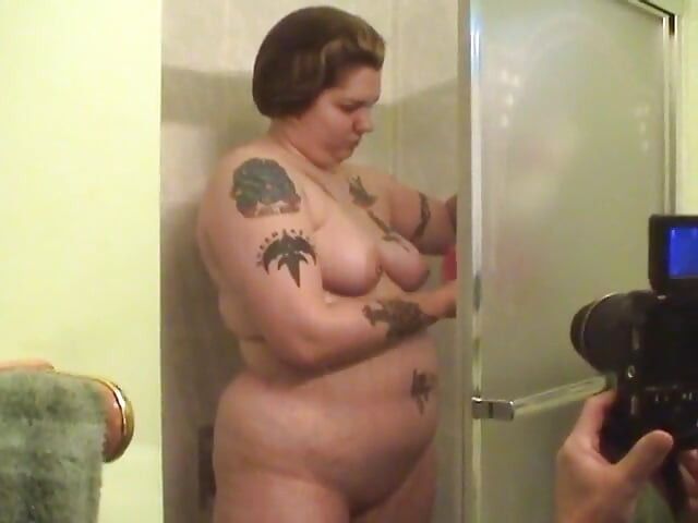 Tattooed fat chick strips to wash her tits and cunt in the shower