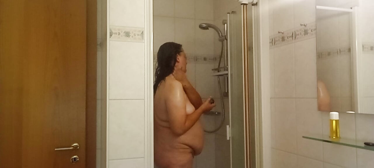 Prava žena tušira meki stomak, mokra koža