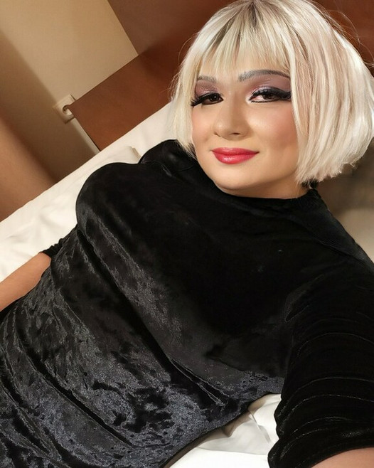 Crossdresser coloca mega consolo longo na bunda sob o vestido de veludo