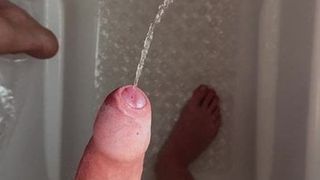 Jerking piss out of an uncut cock in the shower
