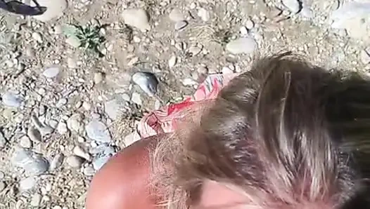 She sucks him at the water's edge