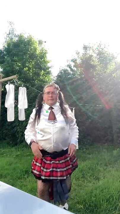 In schoolgirl outfit to hang the laundry