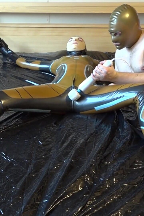 Latex Danielle is attached to the bed and masturbated with the massage vibrator