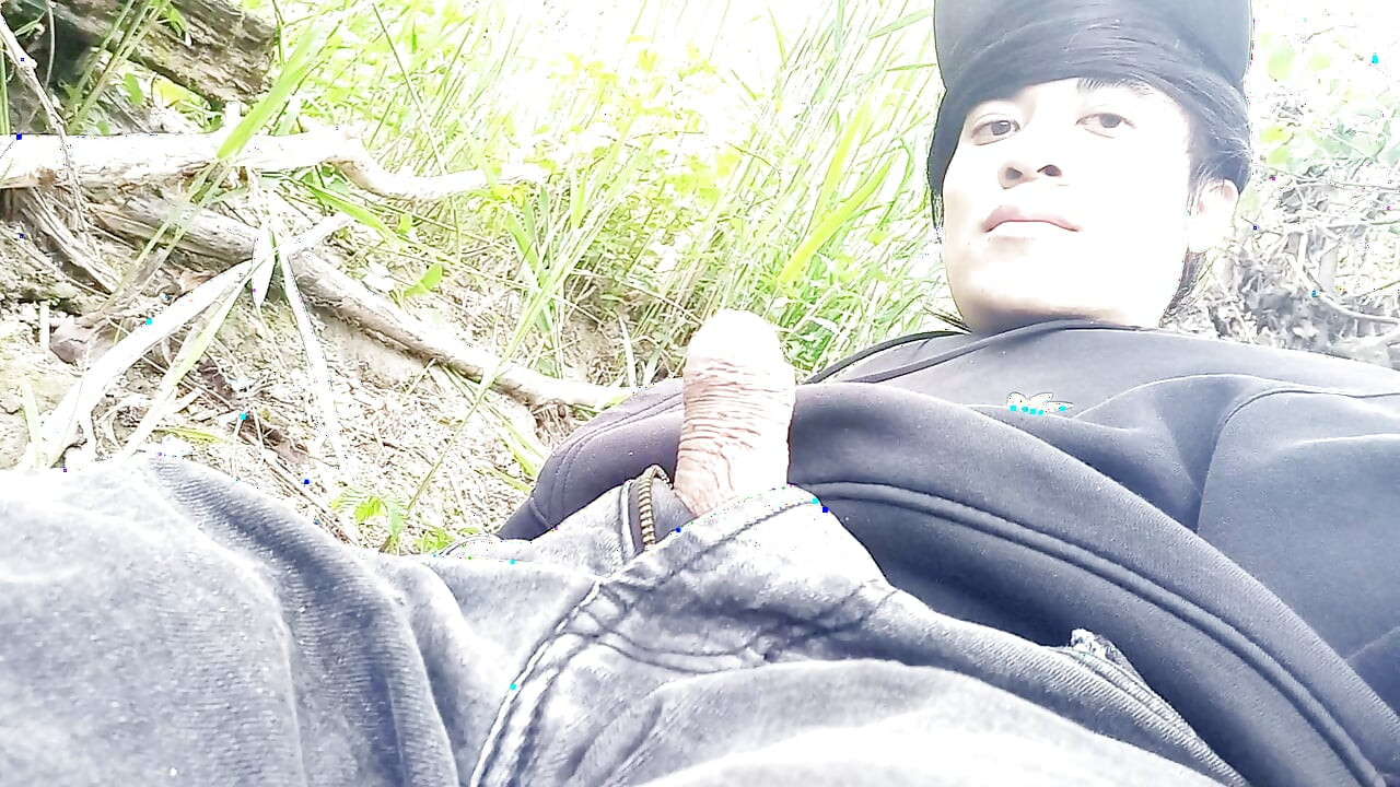 The cute gay twink jerking off his cock, pulled through his fly while outdoors, is Jon Arteen