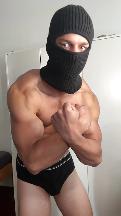 Masked young hunk showing off his muscles