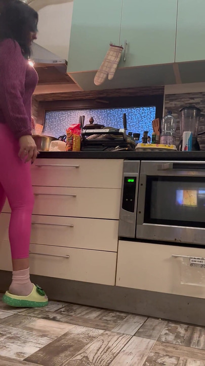 부엌에서 핑크 가죽 레깅스와 카멜토 애널