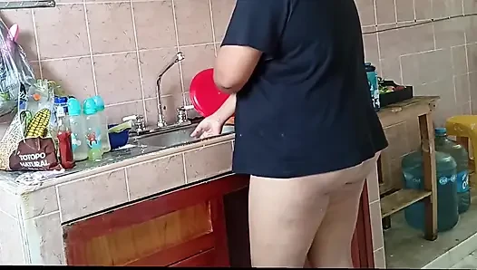 Tombul üvey anne mutfağı yıkıyor ve temiziyor