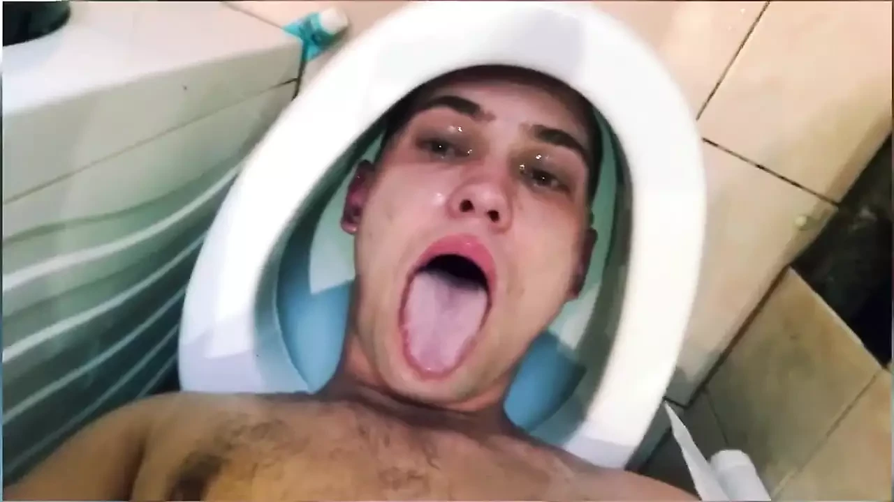 Ragazzo carino piscia sulla stessa faccia mentre la sua testa è in bagno. Usa la sua bocca come in bagno – schiavo in bagno