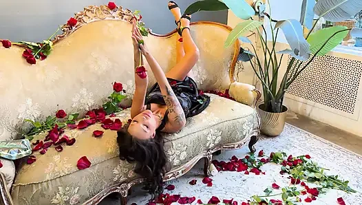 Schöne monika fox im schwarzen kleid auf sofa mit rosen