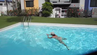 Взрослая женщина купается в бассейне обнаженной