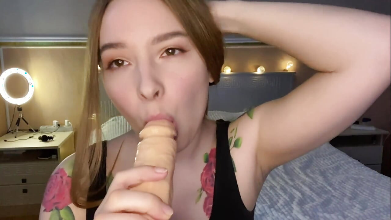 Chupa vibrador e olha para a câmera